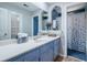 Elegant bathroom featuring blue vanity with a white countertop and a separate shower space at 1420 Hillside Se Pl, Conyers, GA 30094