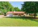 Charming home featuring a well-manicured lawn, inviting front porch, and attached garage at 1420 Hillside Se Pl, Conyers, GA 30094