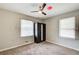 Inviting bedroom features neutral decor, a ceiling fan, and a dark armoire, creating a serene and personalized space at 2564 Riggs Dr, East Point, GA 30344