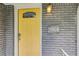 Close-up of the bright yellow front door with house number and stylish light fixture at 2564 Riggs Dr, East Point, GA 30344