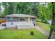 Well-kept raised ranch home with a bright yellow door, mature trees, and large front yard at 2564 Riggs Dr, East Point, GA 30344