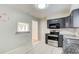 Well-lit kitchen featuring stainless steel appliances, gray cabinetry, granite countertops, and a classic subway tile backsplash at 2564 Riggs Dr, East Point, GA 30344