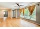 Bright living room boasts hardwood floors, ceiling fan and large windows with warm drapes at 2564 Riggs Dr, East Point, GA 30344