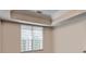 Bright bedroom featuring a large window with blinds and a tray ceiling at 3500 Sweetwater Rd # 522, Duluth, GA 30096