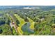 Scenic aerial view of a golf course community featuring a tranquil lake surrounded by lush greenery and beautiful homes at 4012 Ironhill Ln, Woodstock, GA 30189