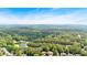 Picturesque aerial view of a neighborhood featuring beautiful homes nestled among abundant trees and a serene lake at 4012 Ironhill Ln, Woodstock, GA 30189