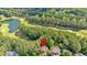 An aerial view displays a home with a pool in a lush, tree-filled neighborhood near a golf course and pond at 4012 Ironhill Ln, Woodstock, GA 30189