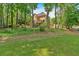 Lush backyard with a swimming pool, deck, and mature trees offering privacy and a connection with nature at 4012 Ironhill Ln, Woodstock, GA 30189