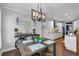 Open dining area with modern lighting fixture, adjacent to a kitchen with white cabinets and stainless appliances at 4012 Ironhill Ln, Woodstock, GA 30189