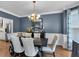 Dining room showcasing blue walls, wainscoting, crown molding, and a decorative chandelier at 4012 Ironhill Ln, Woodstock, GA 30189