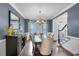 Dining room featuring blue walls, crown molding, dark wood floors, and elegant chandelier lighting at 4012 Ironhill Ln, Woodstock, GA 30189