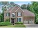 Charming brick home with a manicured lawn and a two-car garage, showcasing classic architectural details at 4012 Ironhill Ln, Woodstock, GA 30189