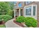 Close-up view of home's entrance featuring a welcoming walkway and lush landscaping with colorful flowers at 4012 Ironhill Ln, Woodstock, GA 30189