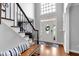 Bright foyer with high ceilings, hardwood floors, staircase with iron railings, and decorative front door at 4012 Ironhill Ln, Woodstock, GA 30189