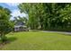 Beautiful backyard features lush green lawn, storage shed, and mature trees for privacy at 129 2Nd Se Ave, Atlanta, GA 30317