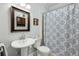 Bathroom featuring pedestal sink, commode, mirror, and blue patterned shower curtain at 129 2Nd Se Ave, Atlanta, GA 30317