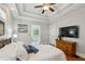 Comfortable bedroom features a tray ceiling, hardwood floors, TV, and ensuite bath at 129 2Nd Se Ave, Atlanta, GA 30317