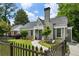Charming brick home with a well-manicured lawn and a picket fence on a sunny day at 129 2Nd Se Ave, Atlanta, GA 30317