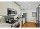 Bright kitchen featuring stainless steel appliances, granite countertops, and custom cabinets with gas range at 129 2Nd Se Ave, Atlanta, GA 30317
