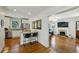 Open kitchen with white cabinets, stainless steel appliances, granite counters, and view to living room with fireplace at 129 2Nd Se Ave, Atlanta, GA 30317