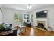 Sunlit living room with hardwood floors, fireplace, and a modern entertainment setup at 129 2Nd Se Ave, Atlanta, GA 30317