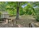 Backyard featuring mature trees, green grass, a storage building, and a wooden deck at 4202 Maplewood Dr, Decatur, GA 30035