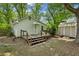 Home's back exterior, featuring a wooden deck, shed, and lush greenery, creating a private outdoor space at 4202 Maplewood Dr, Decatur, GA 30035