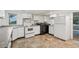 Kitchen area with white cabinets, appliances, and tile flooring at 4202 Maplewood Dr, Decatur, GA 30035