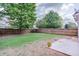 A well-maintained backyard with a green lawn, a wooden fence, and a concrete patio at 5730 Weddington Dr, Cumming, GA 30040