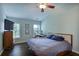 Comfortable bedroom featuring a ceiling fan, hardwood floors, a window with blinds, and a stylish desk at 5730 Weddington Dr, Cumming, GA 30040