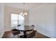 This dining room features hardwood floors, wainscotting, and a modern chandelier at 5730 Weddington Dr, Cumming, GA 30040