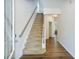 Bright entryway with wood floors, a staircase, and view into a cozy living space at 5730 Weddington Dr, Cumming, GA 30040
