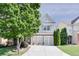 Charming home with a two-car garage, stone accents, manicured lawn, and mature landscaping at 5730 Weddington Dr, Cumming, GA 30040