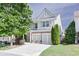 Charming home with a two-car garage, stone accents, manicured lawn, and mature landscaping at 5730 Weddington Dr, Cumming, GA 30040