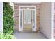Inviting front door with stone accents and decorative window, framed by manicured landscaping at 5730 Weddington Dr, Cumming, GA 30040
