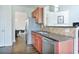 Galley kitchen boasts granite countertops, stainless appliances, and tiled backsplash at 5730 Weddington Dr, Cumming, GA 30040