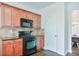 Galley kitchen featuring cherry cabinets and stainless appliances at 5730 Weddington Dr, Cumming, GA 30040