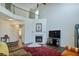 Spacious living room with tall ceilings, large windows, fireplace, hardwood floors, and balcony views at 5730 Weddington Dr, Cumming, GA 30040