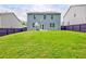 View of large grass backyard between two houses with a wood privacy fence at 7730 Demeter Dr, Fairburn, GA 30213