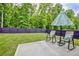 The backyard features green lawn, an umbrella for shade and rocking chairs to relax on at 7730 Demeter Dr, Fairburn, GA 30213