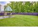 The backyard features green lawn, an umbrella for shade and rocking chairs to relax on at 7730 Demeter Dr, Fairburn, GA 30213
