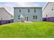 Large grass backyard of blue home featuring privacy fence and patio with seating at 7730 Demeter Dr, Fairburn, GA 30213