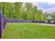Landscaped backyard features green lawn, privacy fence, and patio with seating area at 7730 Demeter Dr, Fairburn, GA 30213