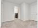 Neutral bedroom with gray carpet and white walls shows door and closet with washer and dryer at 7730 Demeter Dr, Fairburn, GA 30213