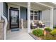 Close up of the welcoming front porch with stylish decor and colorful plants at 7730 Demeter Dr, Fairburn, GA 30213