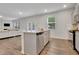 Open concept kitchen with a large island, stainless appliances, and a view into the living area at 7730 Demeter Dr, Fairburn, GA 30213