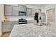 Close up of an eat-in kitchen featuring gray cabinets, granite countertops, and modern appliances at 7730 Demeter Dr, Fairburn, GA 30213