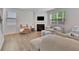 Cozy living room with a fireplace, wood floors, and plenty of natural light at 7730 Demeter Dr, Fairburn, GA 30213
