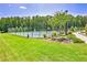 View of community tennis court behind a tall wired fence surrounded by trees at 7730 Demeter Dr, Fairburn, GA 30213