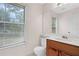 Bright bathroom with a large window, a vanity, and a toilet at 991 Lisa Kay Dr, Lawrenceville, GA 30046